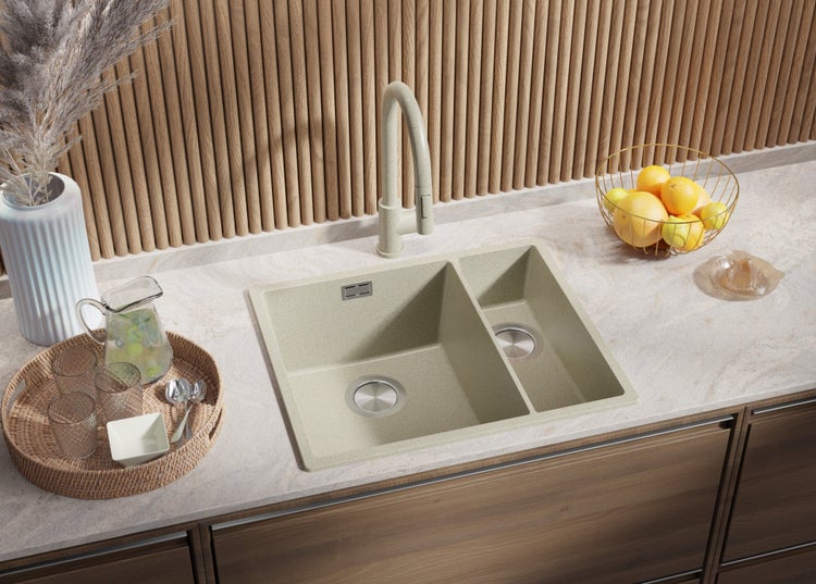 Küchenszene mit Doppelspüle, Armatur und Dekorationsgegenständen auf einer Arbeitsplatte.