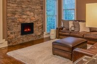 Wohnzimmer mit Steinkamin, elektrischem Kamineinsatz und Ledersofa