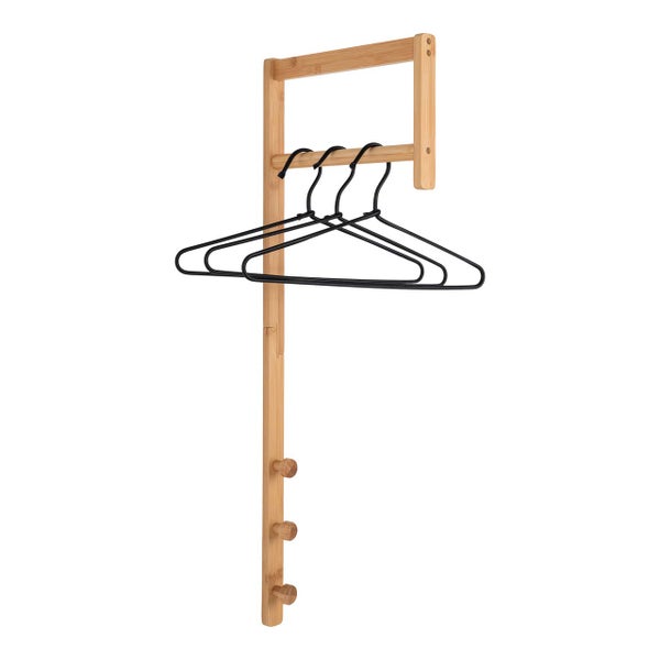 Wandgarderobe aus Bambus mit Kleiderstange, drei schwarzen Kleiderbügeln und drei Haken.