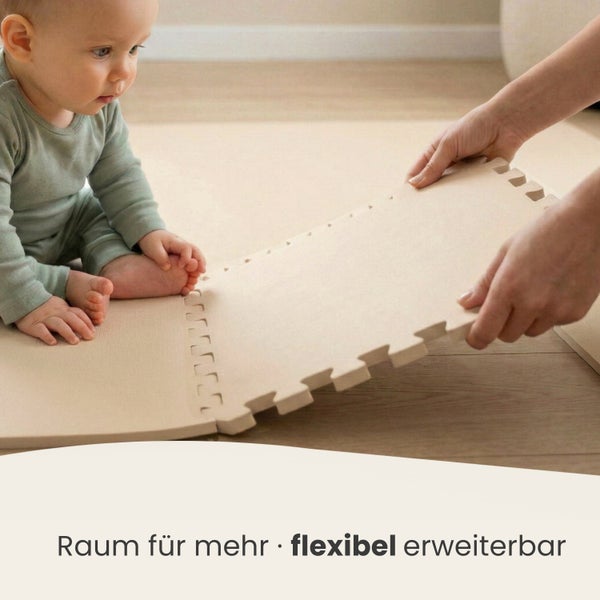Ein Baby sitzt auf einer beigen Puzzlematte aus Schaumstoff während Hände ein weiteres Teilstück zur flexiblen Erweiterung anfügen.