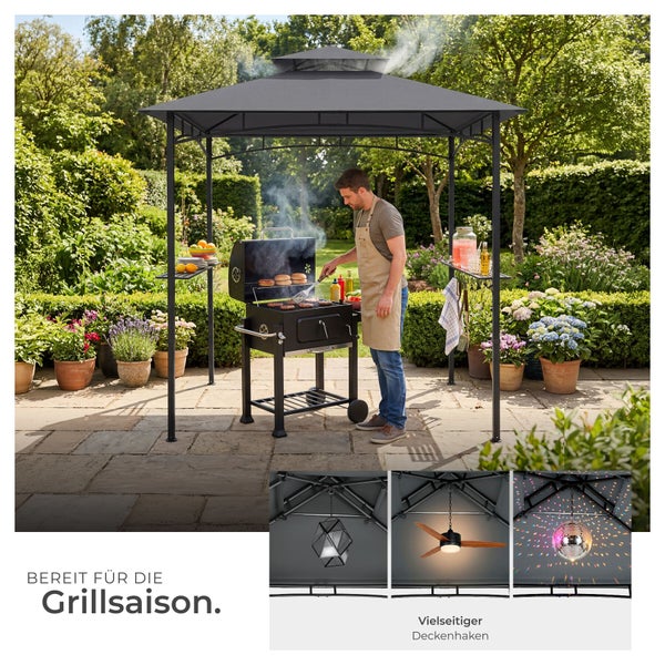 Ein Mann grillt unter einem dunkelgrauen Grillpavillon mit Doppeldach und Seitenablagen in einem hellen Garten; Detailansicht vielseitiger Deckenhaken.