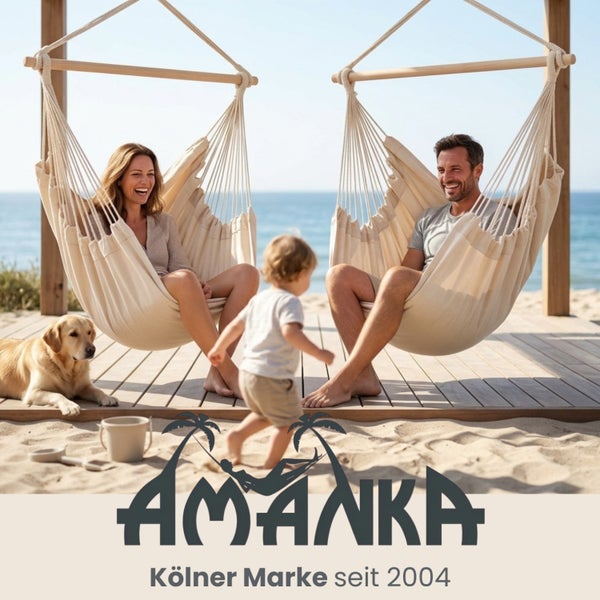 Zwei Hängesessel aus beigem Stoff mit Holzstab auf einer Holzterrasse am Strand mit Personen und Hund. Amanka Logo.