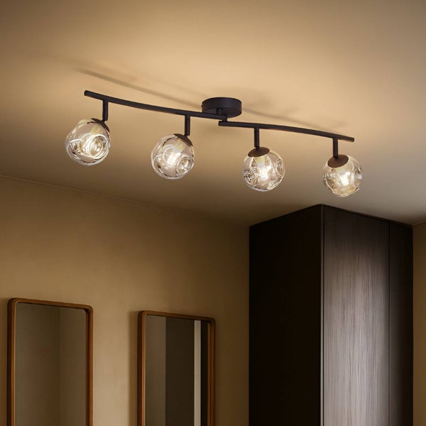 Deckenleuchte mit vier Glaslampenschirmen an einer gebogenen Halterung