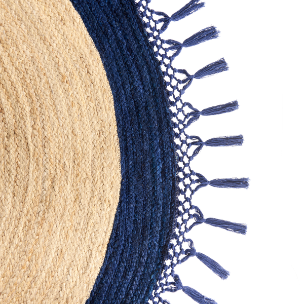 Detailansicht eines runden Jute-Teppichs mit blauem Rand und dekorativen Quasten.