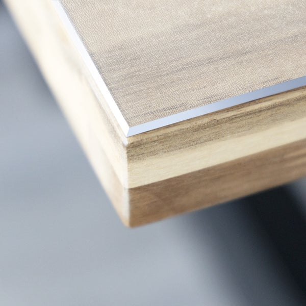 Detailansicht einer Tischplatte mit Holzstruktur und Metallkante