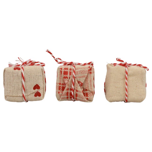 Drei Geschenkattrappen mit unterschiedlichen Mustern und rot-weißer Kordel