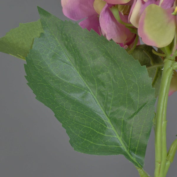 Detailaufnahme eines grünen Blattes einer künstlichen Hortensie mit gezacktem Rand und Stiel.
