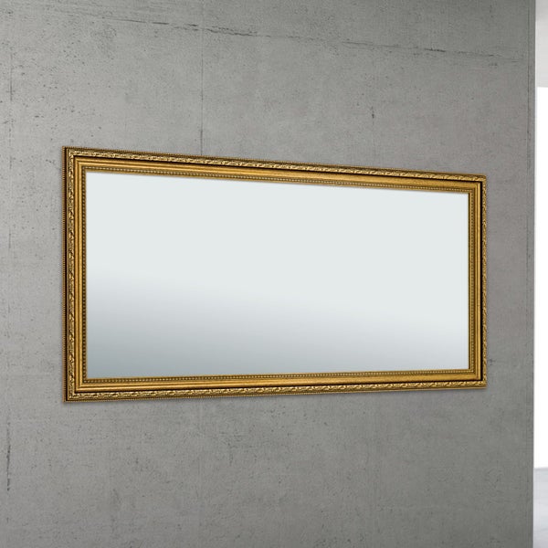Rechteckiger Wandspiegel mit einem verzierten Rahmen im antiken Stil an einer grauen Wand