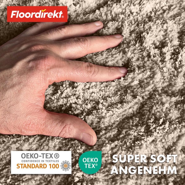 Detailansicht eines hochflorigen Teppichs mit Hand und den Siegeln Oeko-Tex Standard 100 und Oeko-Tex