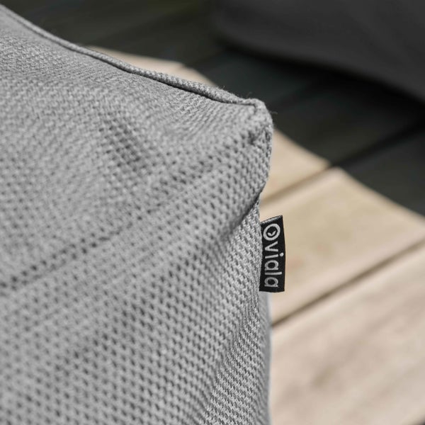 Nahaufnahme eines grauen Kissens aus Webstoff mit Oviala Logo an einem kleinen schwarzen Etikett.