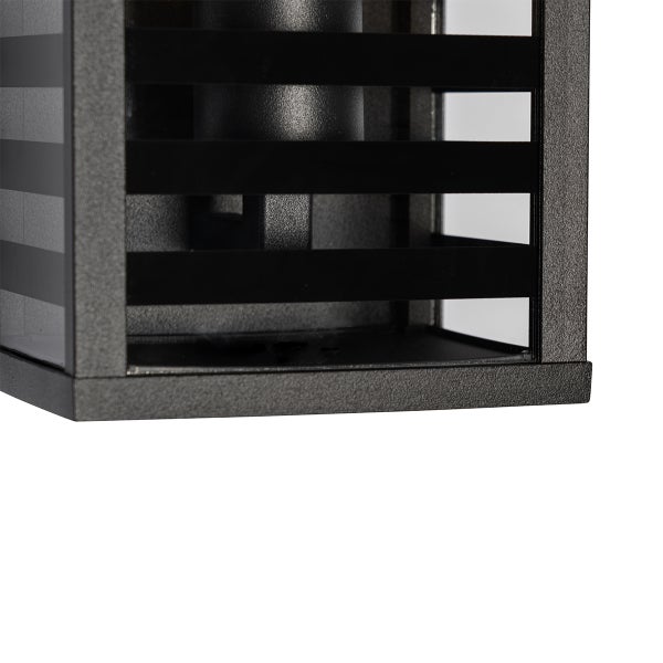 Detailaufnahme einer rechteckigen Außenwandleuchte mit schwarzen Metalllamellen und Glaseinsätzen.