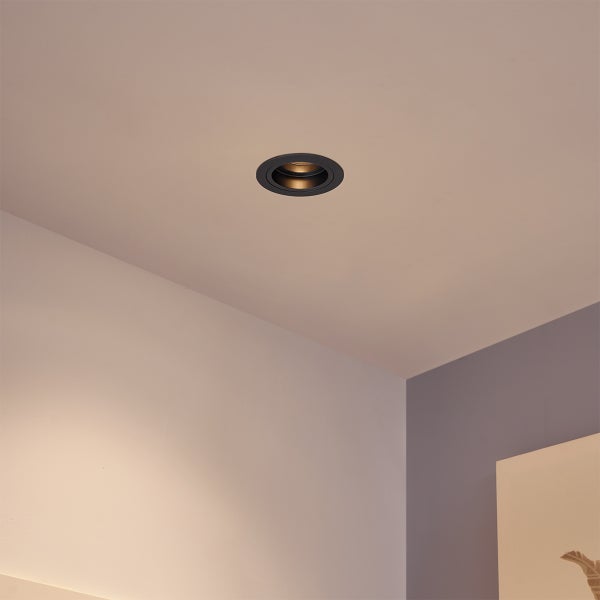 Runder LED-Einbaustrahler in Schwarz und Gold, bündig in eine Decke eingebaut.