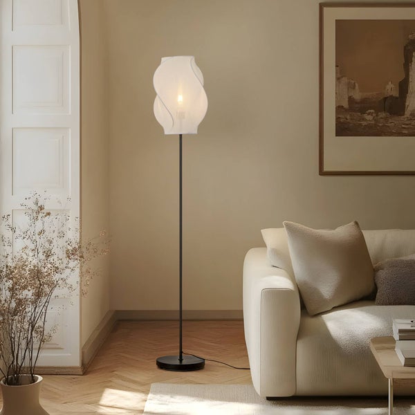Stehleuchte mit weißem Lampenschirm und schwarzem Ständer im Wohnzimmer.