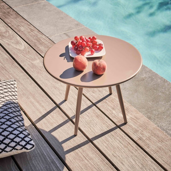 Runder Beistelltisch aus Metall auf einer Holzterrasse am Pool mit Früchten dekoriert in einer hellen und organisierten Umgebung.