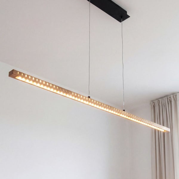 Moderne LED-Pendelleuchte aus Holz in länglicher Form mit warmweißem Licht.