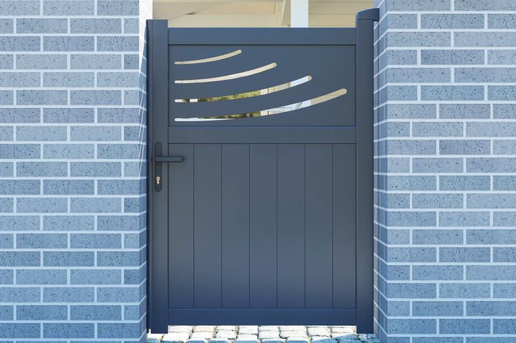 Modernes Gartentor in Anthrazit mit dekorativen Ausschnitten und senkrechten Streben, montiert zwischen gemauerten Pfeilern.