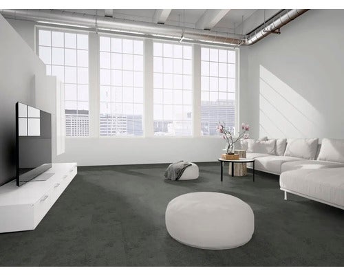 Dunkelgrauer Teppichboden in einem hellen, modernen Wohnzimmer mit weißem Sofa, TV-Board und großen Fensterfronten im Loft-Stil.