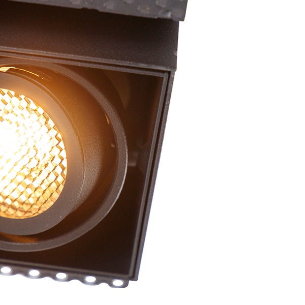 Detailaufnahme eines quadratischen LED-Einbaustrahlers mit Wabenlinse und warmem Licht.