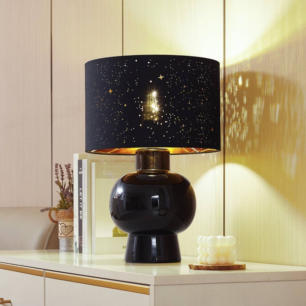 Dekorative Tischleuchte mit Sternenmuster auf einem Sideboard.