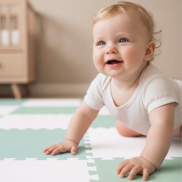 Ein Baby krabbelt auf einer weichen Puzzlematte aus Schaumstoff in einem hellen Zimmer.