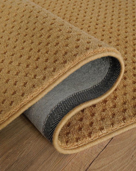 Strukturierter Teppich mit kleinem geometrischem Muster auf einem Holzfußboden.