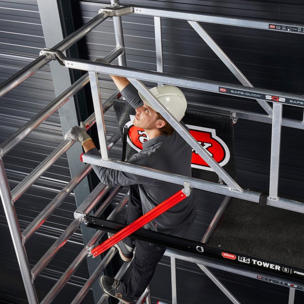 Ein Mann montiert ein Altrex Fahrgerüst im Innenbereich.