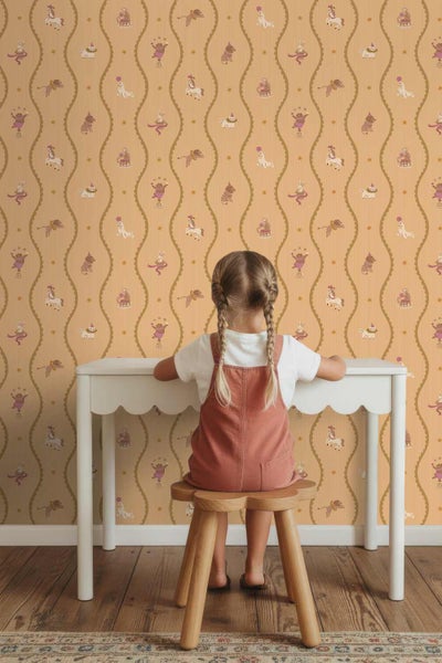 Vliestapete für Kinder mit Zirkusmotiven und Tieren in vertikalen Wellenlinien, Szene mit einem Kind an einem Schreibtisch.