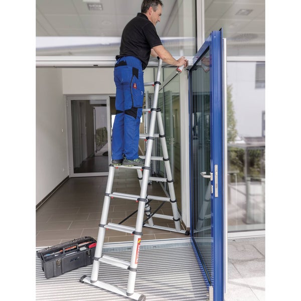 Handwerker auf einer Teleskopleiter bei Reparaturarbeiten an einer Glastür