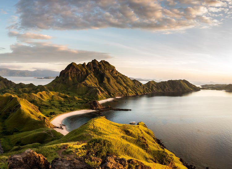Fototapete mit Landschaft der Insel Padar in Indonesien, grüne Hügel, weiße Sandstrände und Meer bei Sonnenuntergang.