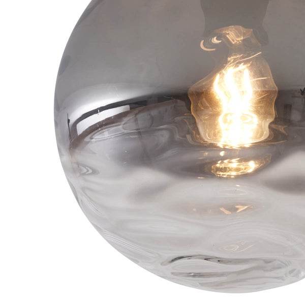 Nahaufnahme einer grauen Glas-Hängeleuchte mit eingeschalteter Glühbirne