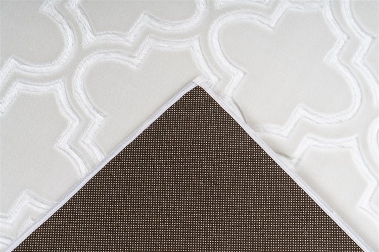 Teppich mit geometrischem Reliefmuster und rutschhemmender Unterseite mit Noppen.