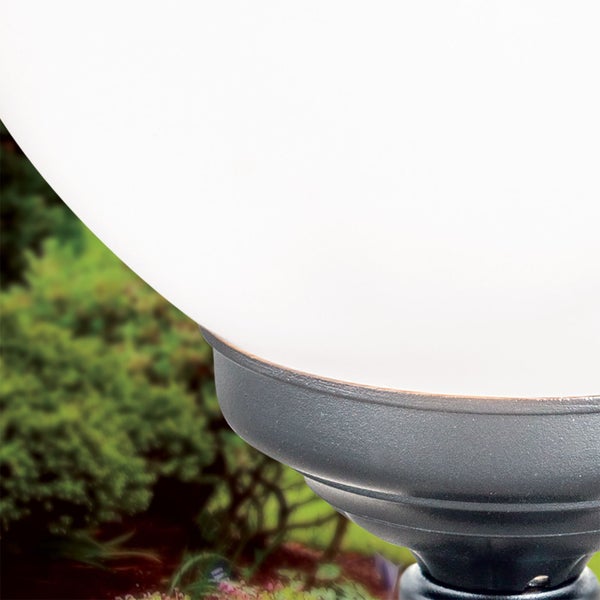 Kugelleuchte für den Außenbereich mit weißem Schirm und dunkelgrauem Metallsockel im Garten.