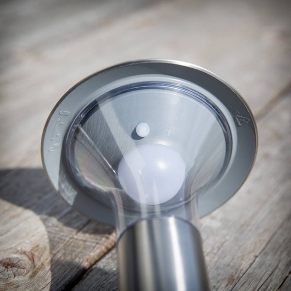 Detailansicht einer Solar-Gartenleuchte aus Edelstahl mit integriertem Sensor und Abdeckung aus Kunststoff.