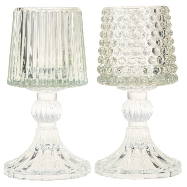 Zwei Windlichter aus Glas auf Fuß, eines mit Noppenstruktur und eines mit vertikalen Rillen.