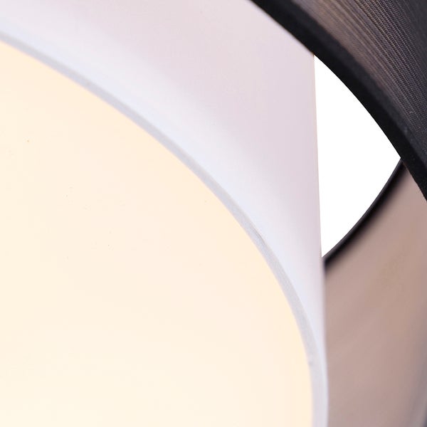Nahaufnahme eines Lampenschirms aus Textil mit weißer Innenseite und schwarzer Außenseite.