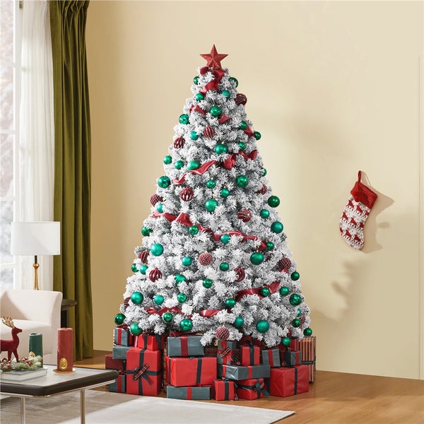 Dekorierter, schneebedeckter Weihnachtsbaum mit Geschenken, Weihnachtskugel und Weihnachtsstrumpf im Wohnzimmer.