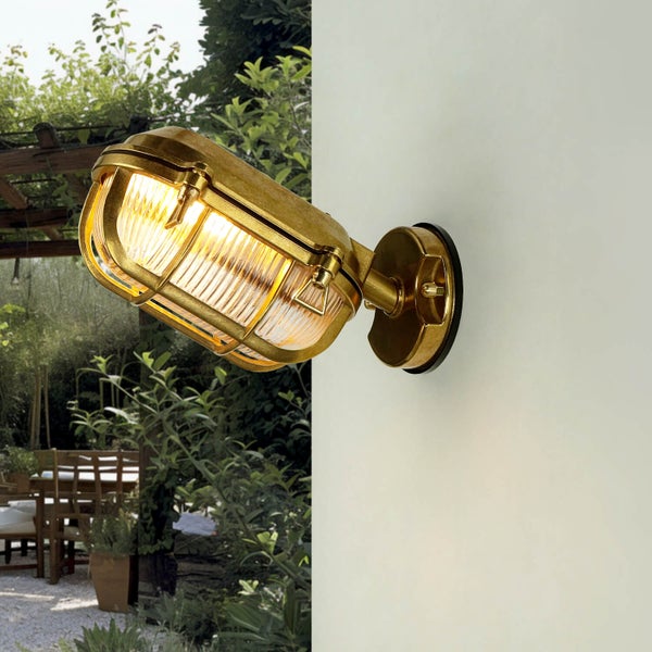 Goldfarbene Wandleuchte mit Gitter im Außenbereich