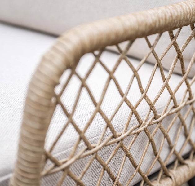 Detailaufnahme eines Gartenmöbels mit Rattan-Geflecht und Sitzkissen.