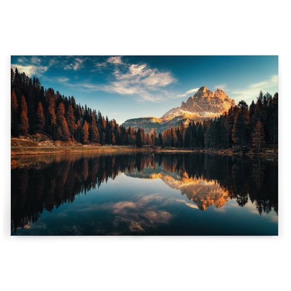 Wandbild mit Motiv von schneebedeckten Bergen und Nadelwald, die sich in einem klaren Bergsee bei Sonnenaufgang spiegeln.