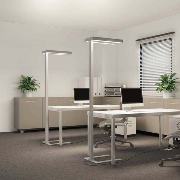 Moderne Büroumgebung mit zwei weißen Schreibtischen, Monitoren und silbernen Stehleuchten in einem hellen, organisierten Raum.