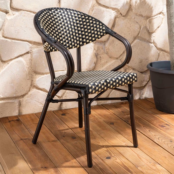 Bistro-Gartenstuhl mit schwarz-beigem Karomuster-Geflecht und dunklem Rahmen auf einer Holzterrasse vor einer Natursteinwand.