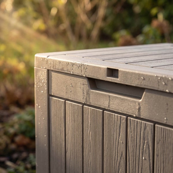Nahaufnahme einer wetterfesten Gartenbox aus Kunststoff in Holzoptik mit Wassertropfen auf der Oberfläche.