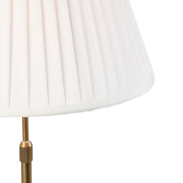 Detailansicht eines weißen Plissee-Lampenschirms auf einem messingfarbenen Metallgestell.