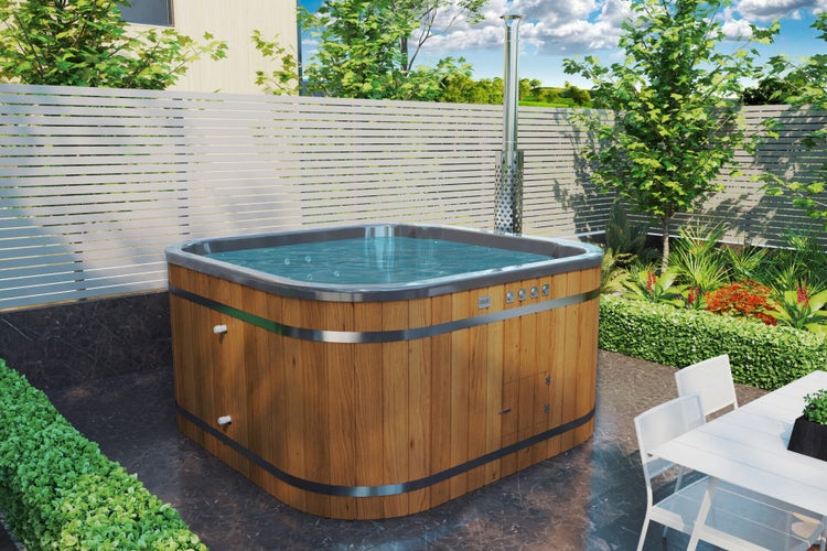Quadratischer Holz-Whirlpool im Garten mit Zaun und Bepflanzung