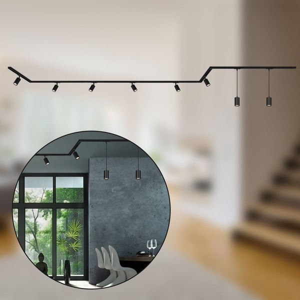 Schwarzes Schienensystem mit mehreren Strahlern an der Decke in einem Wohnzimmer.