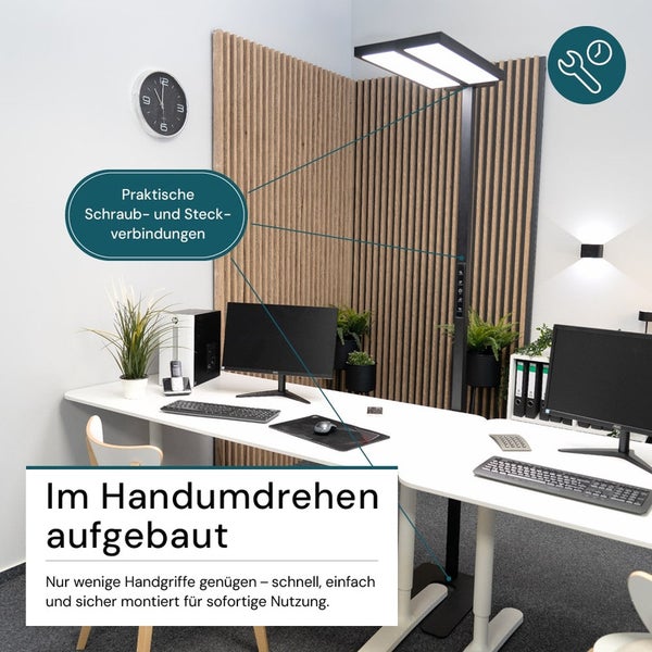 Büro mit höhenverstellbarem Schreibtisch, Monitor, Computer und Stehleuchte