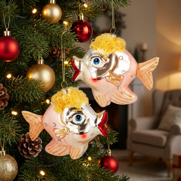 Zwei Glasfisch Anhänger als Weihnachtsbaumschmuck in einem festlich geschmückten Tannenbaum hängend