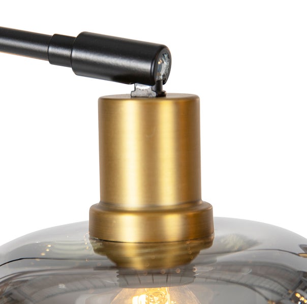 Detailaufnahme einer Lampe mit Lampenschirm aus Glas und einem Lampenarm aus Metall