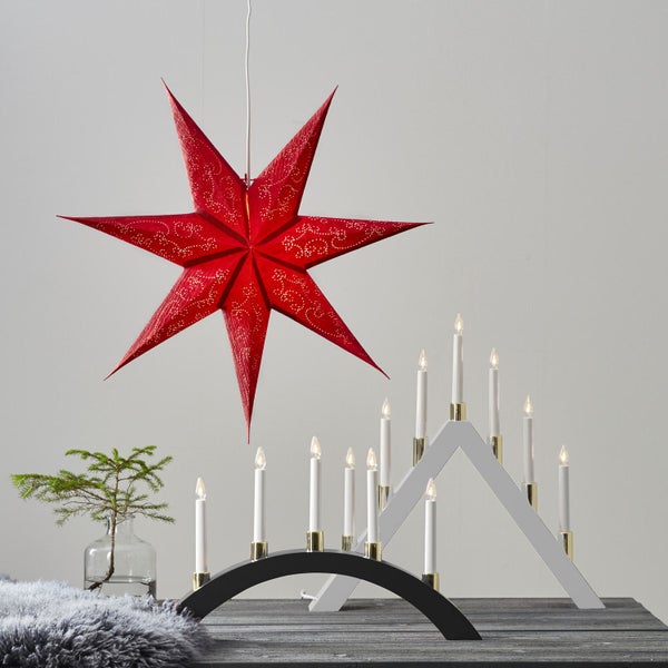 Dekorative Szene mit einem roten Papierstern, zwei Lichterbögen und einem kleinen Baum in einer Vase.