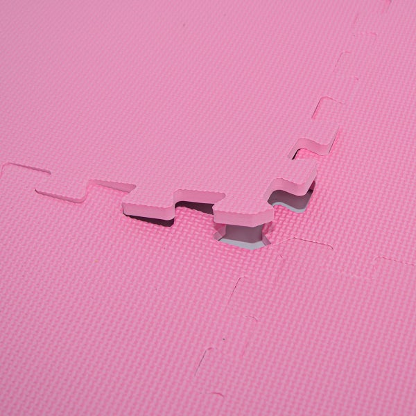Pinkfarbene Schaumstoff-Puzzlematte mit strukturierter Oberfläche und ineinandergreifenden Kanten in Nahaufnahme.
